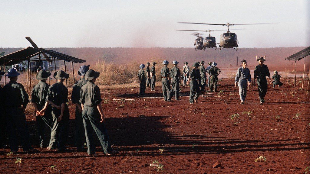 Army soldiers on the field with helicopters
